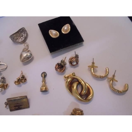 1033 - A mixed lot of earrings and charms including a silver butterfly.