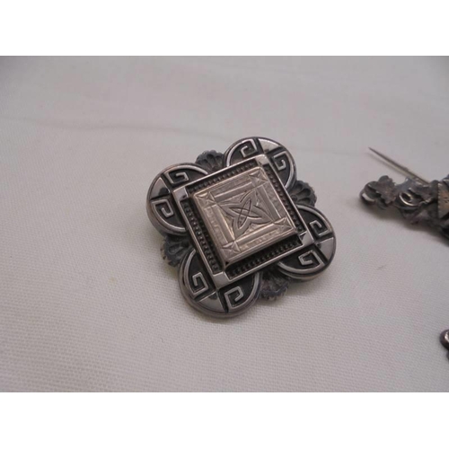 1043 - Three vintage silver brooches and a silver fob.