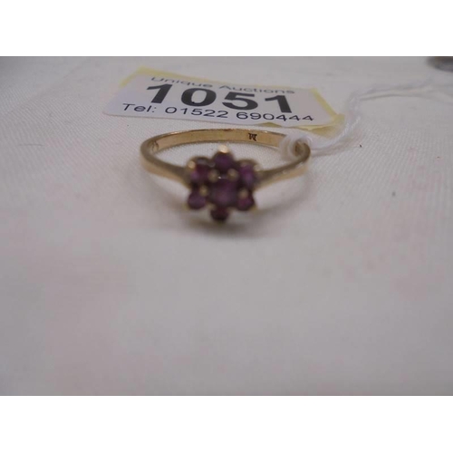 1051 - A ruby stone set ring in a cluster design, hall marked London 1965, size O half, 1.4 grams.