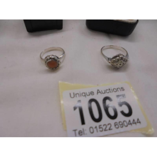 1065 - Three silver rings and one un-marked ring.