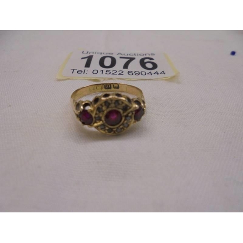 1076 - An 18ct gold rings set diamonds and possibly rubies, size M, 2.46 grams.