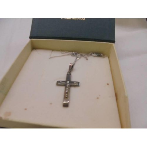 1077 - Three silver chains, five silver rings and a silver crucifix, 4 ounces.