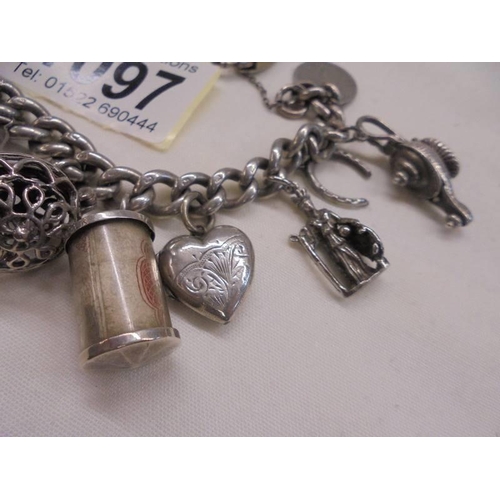 1097 - A silver charm bracelet with mainly silver charms.