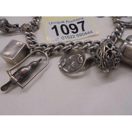 1097 - A silver charm bracelet with mainly silver charms.