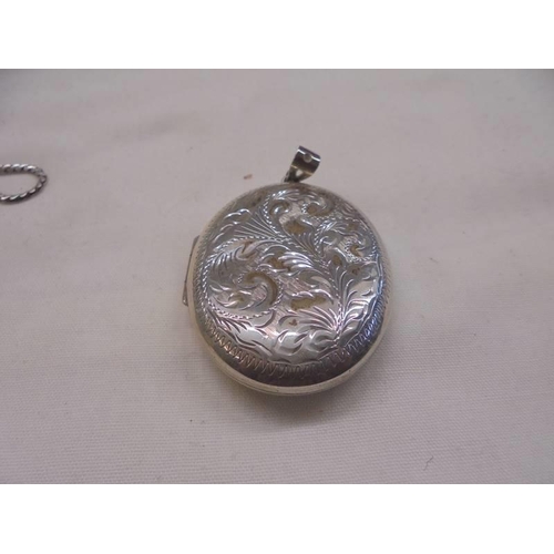 1101 - A silver locket, two white metal lockets and a miniature cigarette lighter.