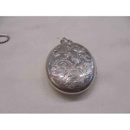 1101 - A silver locket, two white metal lockets and a miniature cigarette lighter.