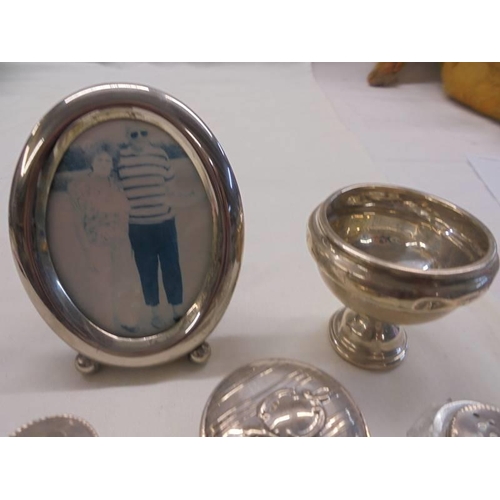 1102 - A small silver footed dish (dinted), three silver topped pots and a white metal photo frame.