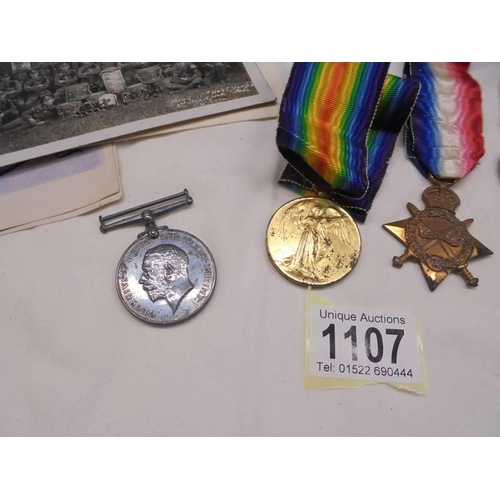 1107 - Three WW1 medals, Two WW2 medals and a quantity of military postcards.