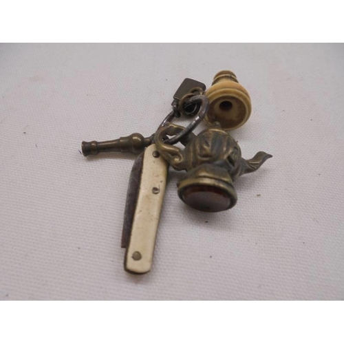 1111 - A miniature Victorian bone monocular stanhope, a miniature penknife and other charms for bracelet.