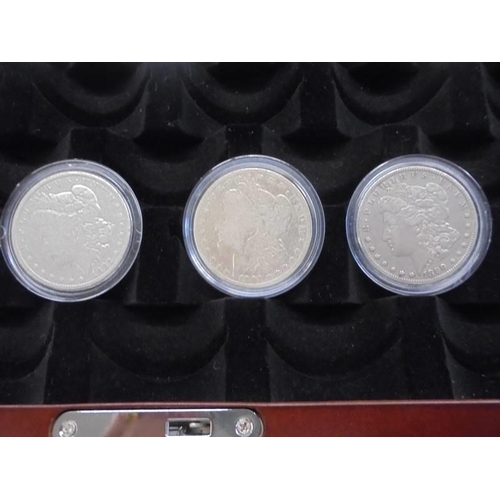 1122 - A collection of ten Morgan silver dollars in case, 1879, 1882, 1891, 1899, 1921 - 1926.