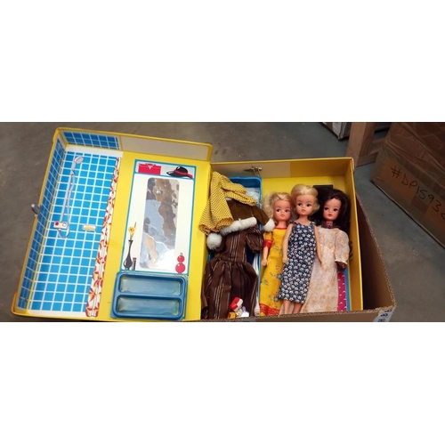 2445 - A suitcase / wardrobe including 3 Sindy dolls