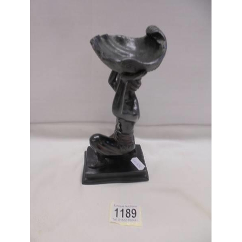 1189 - A bronze figure of a kneeling man holding a large shell above his head.