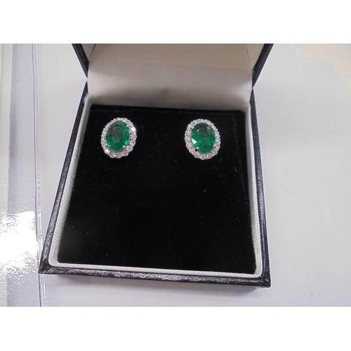 1209 - Certificated pair of 18ct white gold oval emerald and diamond cluster studs, boxed. Emeralds 3.20ct.... 