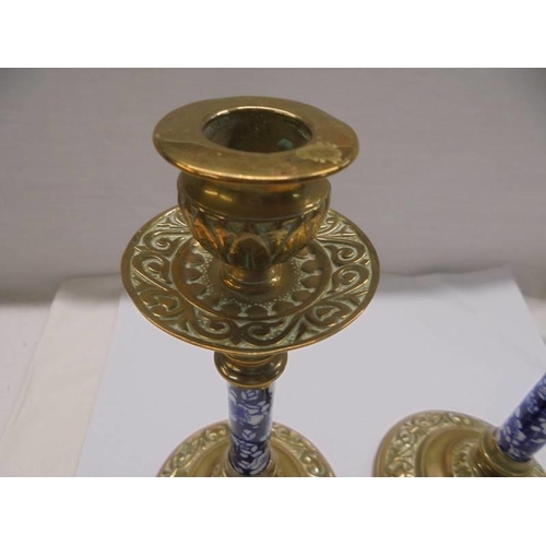 1270 - A pair of Victorian brass candlesticks with blue and white ceramic columns.