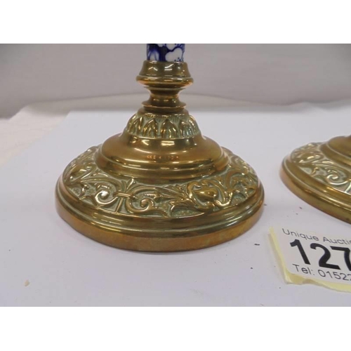 1270 - A pair of Victorian brass candlesticks with blue and white ceramic columns.