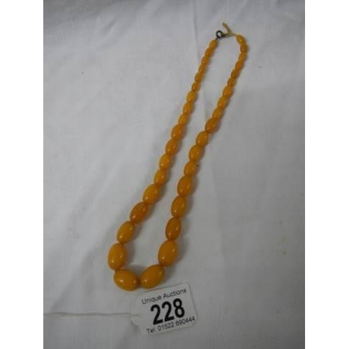 228 - An old amber coloured necklace.