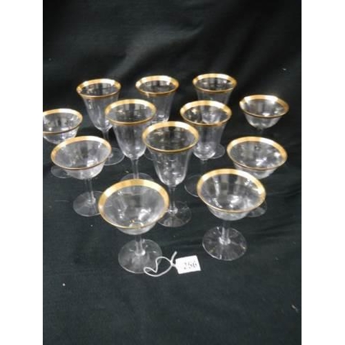 256 - Two sets of six glasses with gilded rims.