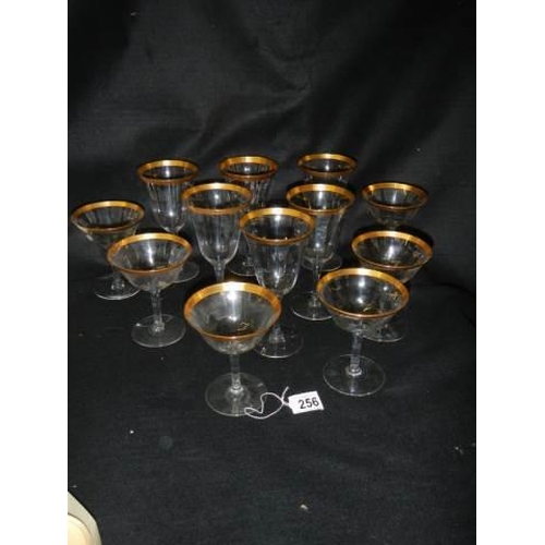 256 - Two sets of six glasses with gilded rims.