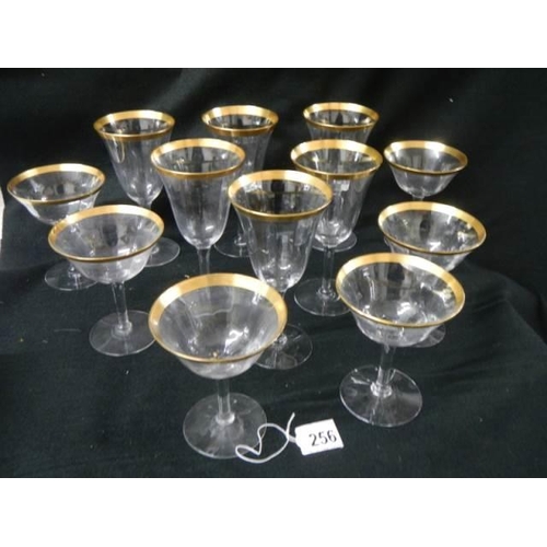 256 - Two sets of six glasses with gilded rims.