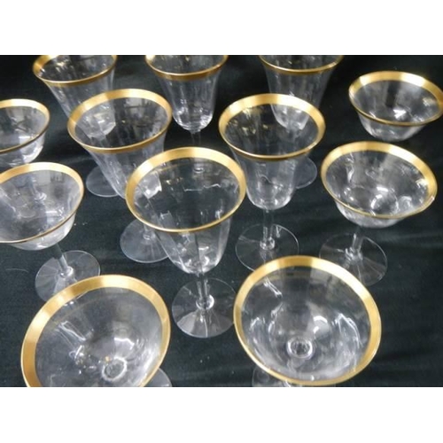 256 - Two sets of six glasses with gilded rims.