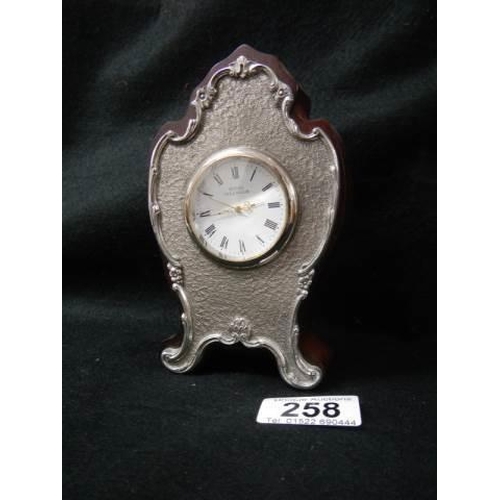 258 - A small late 20th century clock with silver plated front.