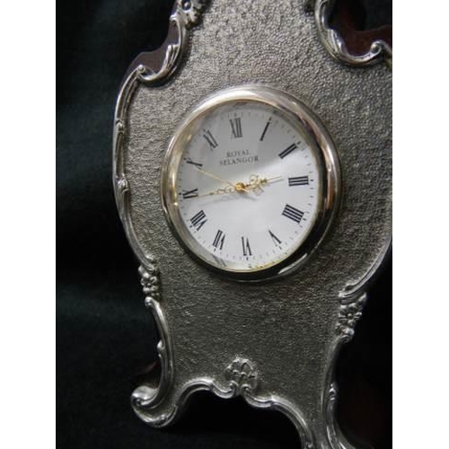 258 - A small late 20th century clock with silver plated front.