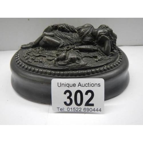 302 - A paperweight featuring a reclining female.