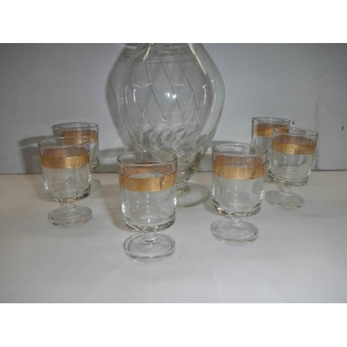 315 - An engraved glass decanter and a set of six gilt rimmed glasses. COLLECT ONLY.