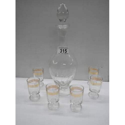 315 - An engraved glass decanter and a set of six gilt rimmed glasses. COLLECT ONLY.