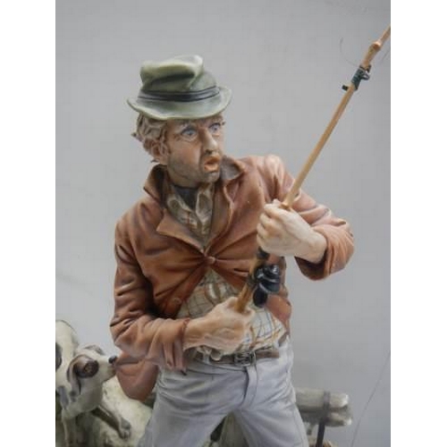 340 - A continental porcelain figure of a fisherman with his dog. COLLECT ONLY.