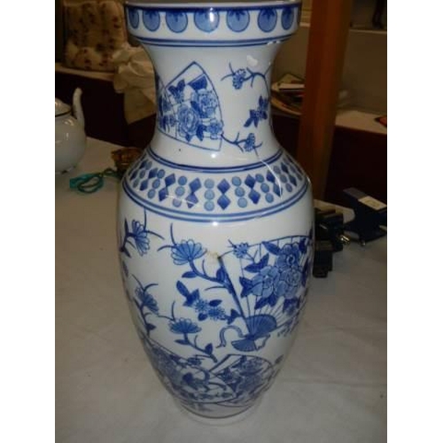 428 - A tall blue and white vase.