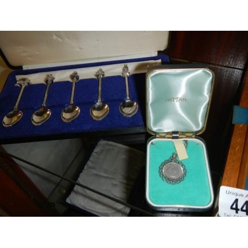 449 - A cased set of knives, cased set of spoons and a medallion.