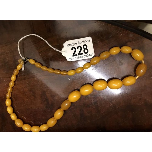 228 - An old amber coloured necklace.