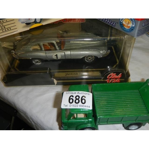 686 - A quantity of boxed and loose die cast vehicles.