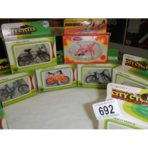 692 - Eight boxed 1/20 scale die cast bicycles.