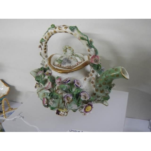 795 - A flower encrusted teapot.