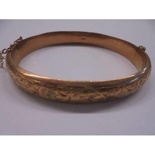 1004 - A 9ct gold engraved bangle, 10.7 grams.