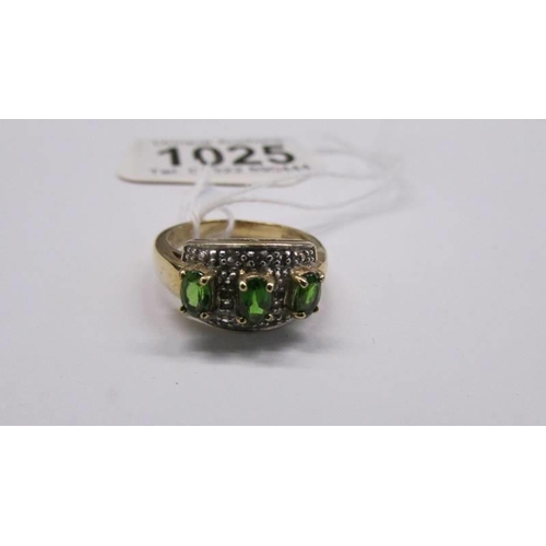 1025 - A 9ct yellow gold three stone emerald and diamond ring, size M half, 4.5 grams.