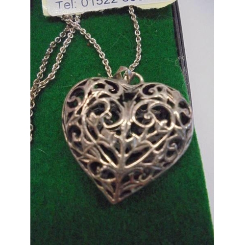 1048 - A silver heart locket with matching earrings.