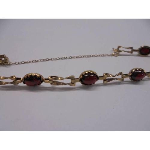 1049 - A 9ct gold bracelet set red stones, 4.6 grams in total.