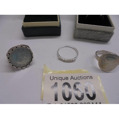 1060 - Two silver rings, two white metal rings and a yellow metal ring.