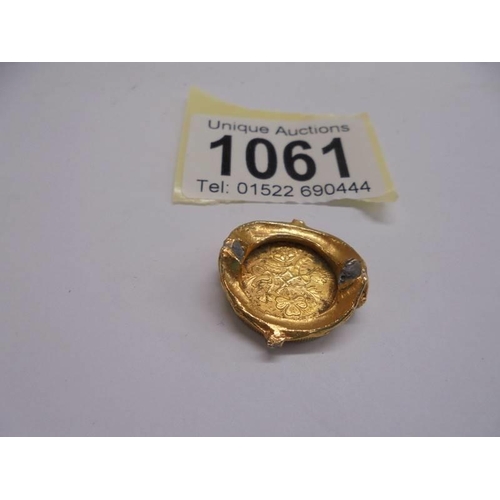 1061 - A gold coloured sixpence in an a/f mount.