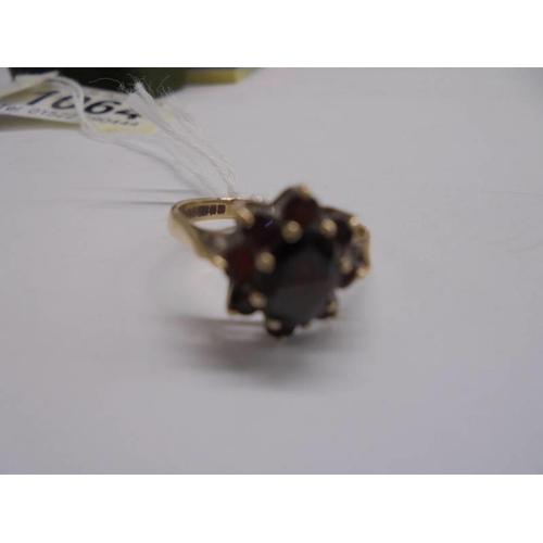 1064 - A 9ct gold ring set garnets, size J half, 2.2 grams.