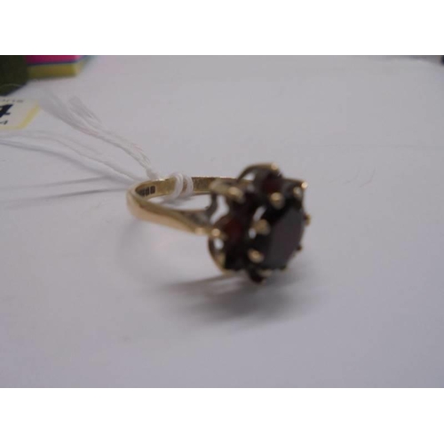 1064 - A 9ct gold ring set garnets, size J half, 2.2 grams.