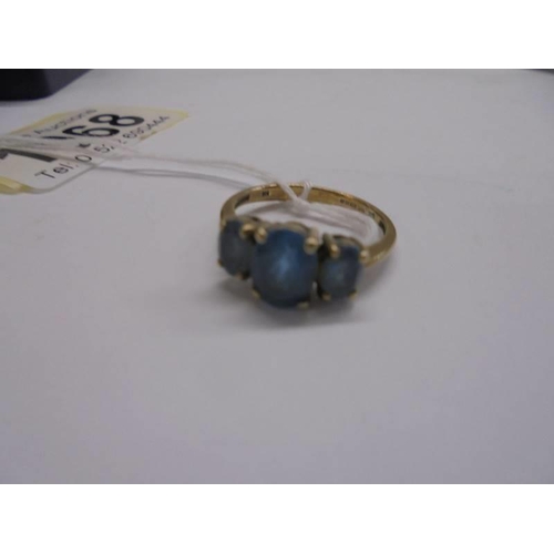 1068 - A 9ct gold ring set three blue stones, size M, 2.6 grams.