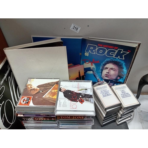 316 - A quantity of CDs, LPs & The history of rock cassettes