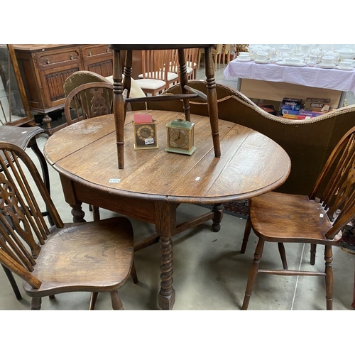 490G - An oval drop leaf table with 4 wheel back chairs