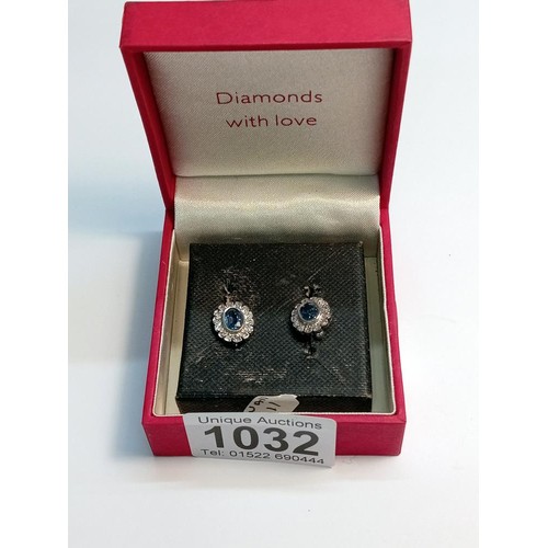 1032 - A pair of oval sapphire and diamond white gold earrings.