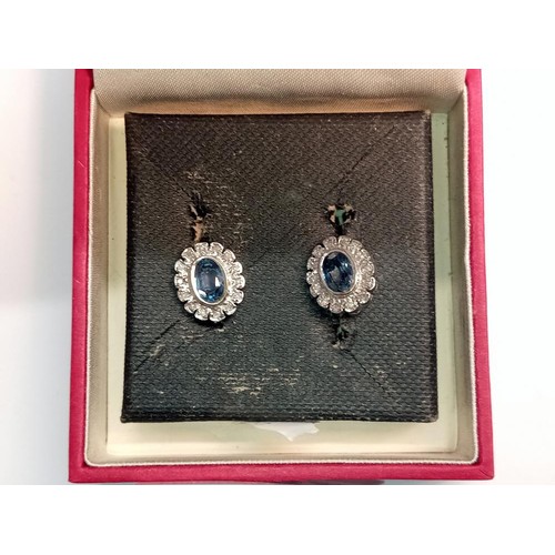 1032 - A pair of oval sapphire and diamond white gold earrings.