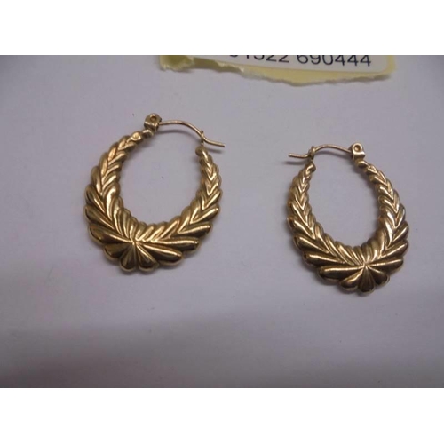 1080 - A pair of 9ct gold fancy design ear hoops.